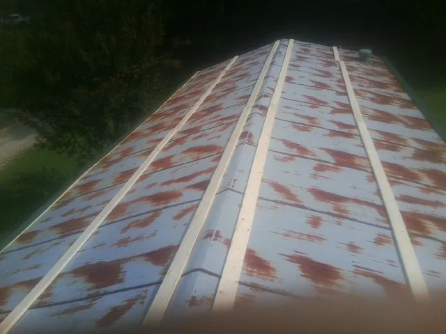 Rusted metal roof panels with new wood purlins before replacement — Storm Damage Roof Repair in Tolland by Roofing Brothers