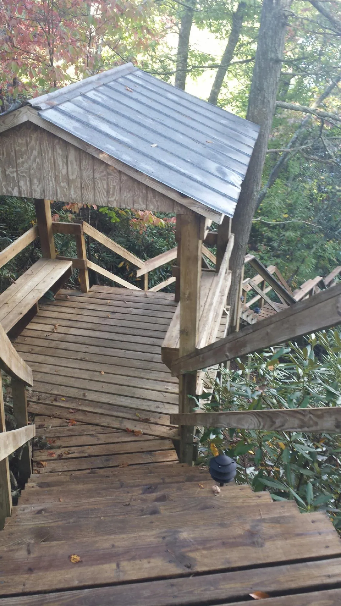 Metal roofed shelter over wooden steps on a wooded walkway — Skylight Repair & Installation work by our crew in Tolland