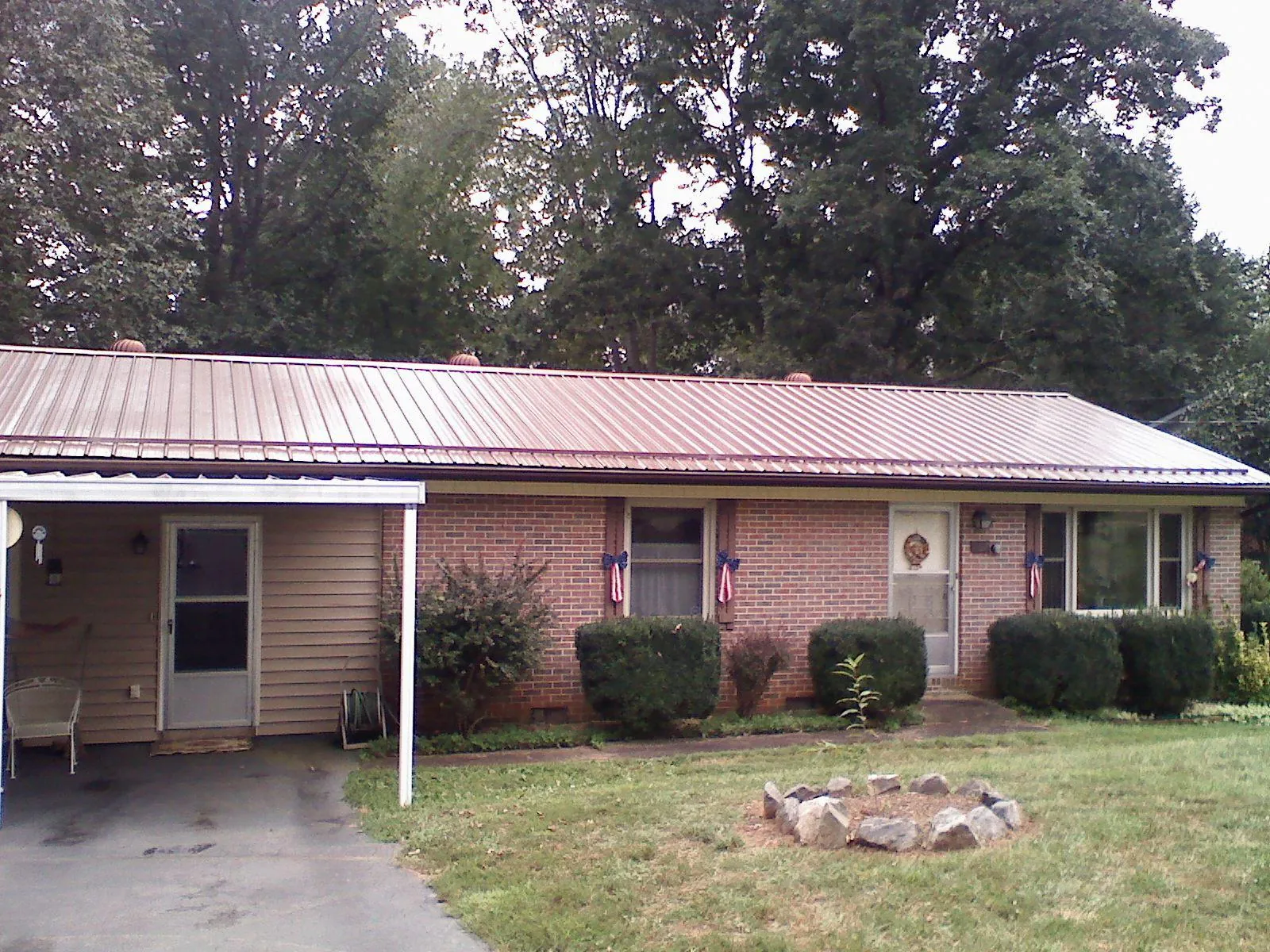 Bronze metal roof and carport on a brick ranch home — Roof Repair work by our crew in Tolland